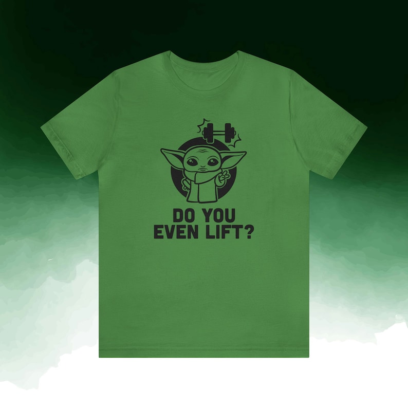 K&ouml;nnte beinhalten: Gr&uuml;nes T-Shirt mit einer schwarzen Grafik eines Zeichentrickcharakters und dem Text "DO YOU EVEN LIFT?". Die Grafik enth&auml;lt eine Hantel und die Figur zeigt das Friedenszeichen.