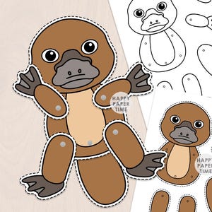 May include: A brown and tan paper platypus craft with articulated limbs attached by metal fasteners. The set includes a fully assembled platypus, a coloured platypus template, and a black and white line art template, all featuring the text Happy Paper Time.