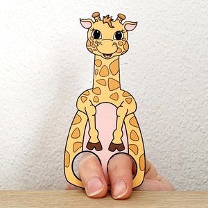 Puede incluir: Un t&iacute;tere de dedo de una jirafa con la barriga rosa y las pezu&ntilde;as marrones. La jirafa tiene un patr&oacute;n de manchas amarillas y naranjas.