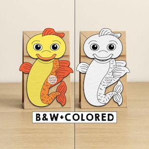 May include: Two brown paper bags, each with a fish design. One fish is yellow and orange, the other is white. The text "HAPPY PAPER TIME" is on the fish. The text "B&W+COLORED" is below the bags.