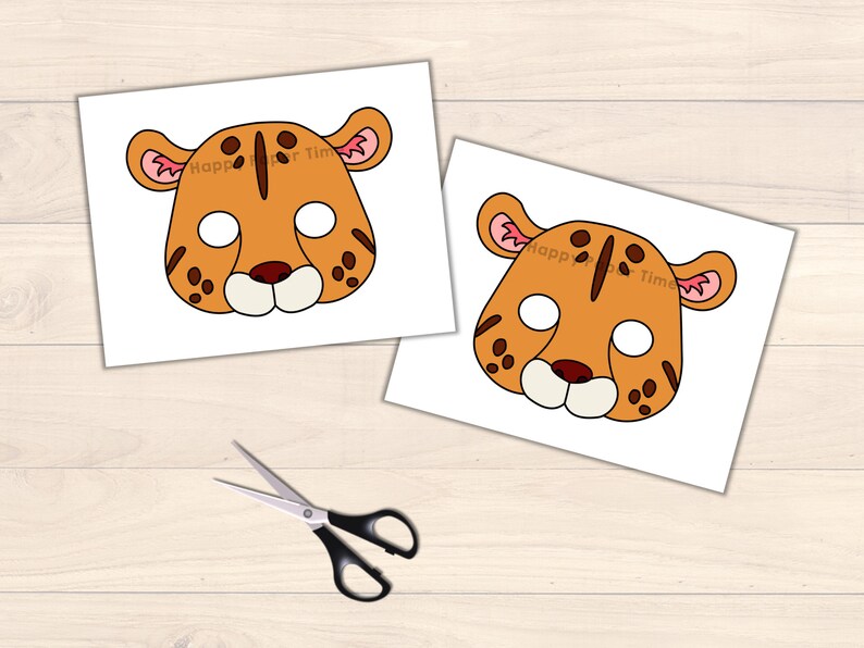 May include: Two printable paper masks of a cheetah with orange fur, black spots, and pink ears. The masks are on white paper with the text "Happy Paper Time" printed on them.