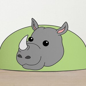 May include: A green and gray paper crown with a cartoon rhinoceros face. The rhinoceros has a large, gray horn and small, black eyes.