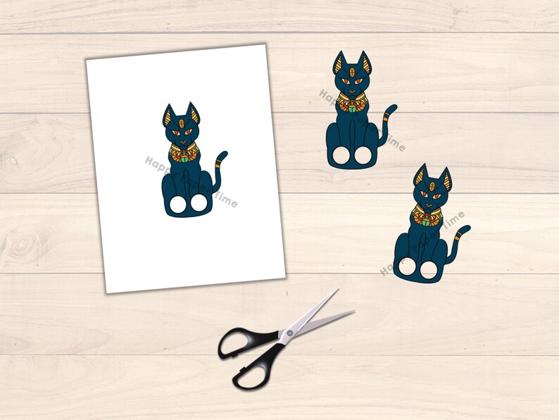 May include: Two printable finger puppets of a blue cat with gold accents. The cat is wearing a gold collar with a jewel. The cat is sitting with its legs crossed and its tail curled around its body.