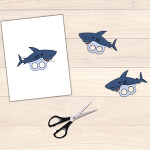 May include: Printable shark finger puppets. Two blue shark finger puppets with white teeth and eyes. The sharks have two holes for fingers.