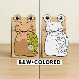May include: Two paper gift bags with snail cutouts. One snail is tan, green, and pink, the other is white. The snail cutouts have large eyes and a smiling mouth. The text "HAPPY PAPER TIME" is on the snail's shell. The text "B&W+COLORED" is below.