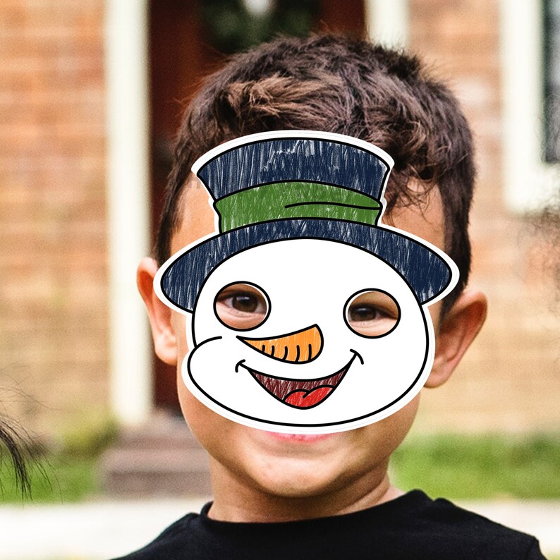 K&ouml;nnte beinhalten: Ein Kind tr&auml;gt eine Schneemannmaske mit einem gr&uuml;n-blauen Hut. Die Maske hat ein l&auml;chelndes Gesicht mit einer orangefarbenen Karottennase und schwarzen Augen.