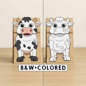 May include: Two brown paper bags featuring a cow illustration. The left bag shows a coloured cow with black spots, pink muzzle, and tan horns. The right bag shows a black and white outline of the same cow. Both bags have the text HAPPY PAPER TIME.