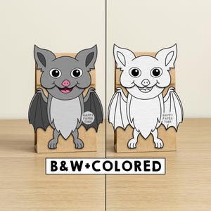 Puede incluir: Dos bolsas de papel para golosinas con recortes de murci&eacute;lagos. Un murci&eacute;lago es gris con alas negras y una lengua rosa, el otro es un contorno blanco. Las bolsas son marrones. El texto en las bolsas dice "HAPPY PAPER TIME". Un letrero debajo dice "B&W+COLORED".