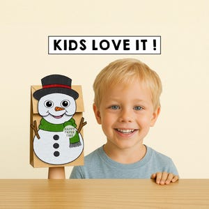 Puede incluir: Un ni&ntilde;o sonriente junto a una bolsa de papel marr&oacute;n decorada con un dise&ntilde;o de mu&ntilde;eco de nieve. El mu&ntilde;eco de nieve tiene un sombrero de copa negro, una bufanda verde y una nariz de zanahoria. El texto "KIDS LOVE IT!" est&aacute; arriba.
