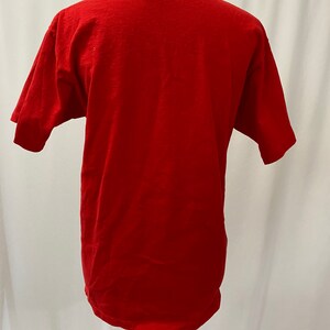 May include: A red short-sleeved t-shirt on a mannequin.