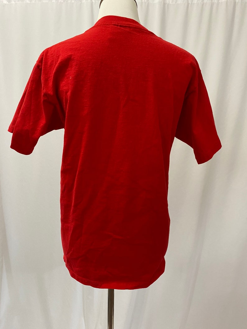 May include: A red short-sleeved t-shirt on a mannequin.
