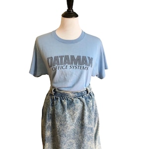 Op de afbeelding: Een lichtblauw T-shirt met een donkerblauwe afbeelding met de tekst "DATAMAX OFFICE SYSTEMS".