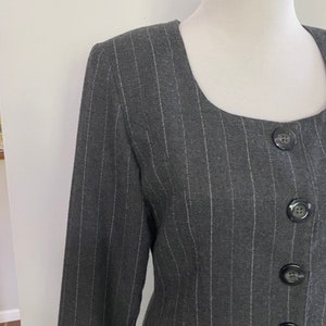 May include: A black and white striped blazer with a square neckline and four black buttons down the front.