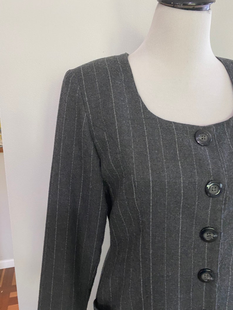May include: A black and white striped blazer with a square neckline and four black buttons down the front.