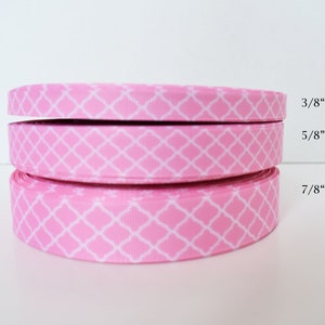 May include: Three rolls of pink ribbon with a white geometric pattern. The ribbon widths are 3/8", 5/8", and 7/8".