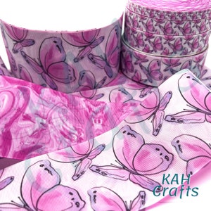 May include: Pink and white ribbon with a butterfly print. The ribbon is made of grosgrain and has a satin finish. The butterflies are pink and white with a watercolor effect. The ribbon is 1.5 inches wide and is perfect for crafting, hair bows, and other projects.