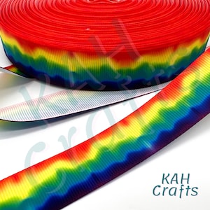 May include: A roll of rainbow-colored ribbon with a vibrant gradient of red, orange, yellow, green, blue, and purple. The ribbon is made of a sturdy material and is suitable for various crafting projects. The text "KAH Crafts" is visible.
