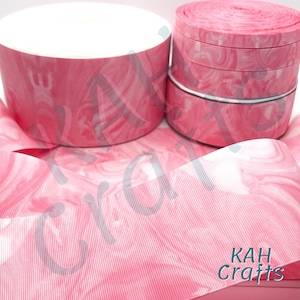 Może przedstawiać: Różowa i biała wstążka marmurowa z białym paskowanym wzorem. Wstążka jest zwinięta, a widoczna jest etykieta "KAH Crafts".