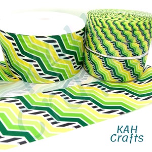 May include: Green and yellow chevron patterned ribbon with black stripes. The ribbon is rolled up and displayed on a white background. The text "KAH Crafts" is visible in the bottom right corner of the image.