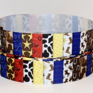 May include: Two spools of decorative ribbon with a western theme. The ribbon features a variety of patterns including stars, cow print, horseshoes, and cowboy boots. The colors include brown, blue, red, yellow, and white.