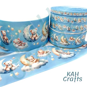 May include: Light blue ribbon featuring a repeating pattern of teddy bears on crescent moons and clouds, with stars. The ribbon is available in rolls and is suitable for crafts and decorations. The text "KAH Crafts" is visible.