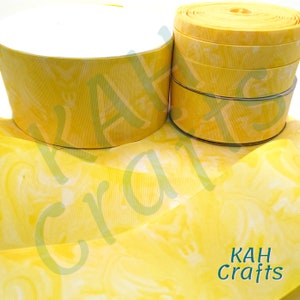 May include: Yellow ribbon with a white marbled pattern. The ribbon is rolled up and the ends are visible. The ribbon is 1.5 inches wide.