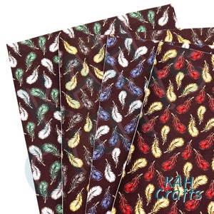 Puede incluir: Cuatro hojas de cuero sintético marrón con un patrón repetitivo de plumas blancas, rojas, azules y amarillas. Las hojas están apiladas una encima de la otra y la hoja inferior tiene el texto "KAHI Crafts" impreso en ella.