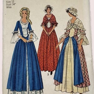 May include: Simplicity sewing pattern featuring three historical costumes. The pattern includes a size 12 with a 34-inch bust. The costumes are in blue, red, and white, with details like ruffles and patterned fabrics. The text reads "COSTUMES FOR THE BICENTENNIAL."