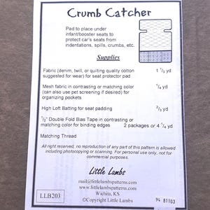 Pu&ograve; includere: Un foglio di carta bianco con il titolo "Crumb Catcher" e un diagramma di un proteggi-sedile per auto. Il testo elenca i materiali necessari, tra cui tessuto, tessuto a rete, ovatta e sbieco. Il modello &egrave; di Little Lambs.