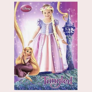May include: A Disney Tangled-themed image showing a girl in a princess dress, a cartoon illustration of Rapunzel, and a castle tower. The dress is lavender and pink, with a floral headband and long blonde braid. The background is purple.