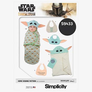 May include: A Simplicity home sewing pattern for baby accessories, featuring a design inspired by The Mandalorian. The pattern includes a baby swaddle, hat, bibs, and a hooded towel, all with a Grogu theme. The pattern is designed and printed in the USA.