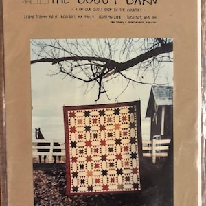 May include: A quilt with a star pattern in red, black, and tan is displayed outdoors. The quilt measures 72" x 86". The image is from "The Buggy Barn," a quilt shop in Reardan, WA.