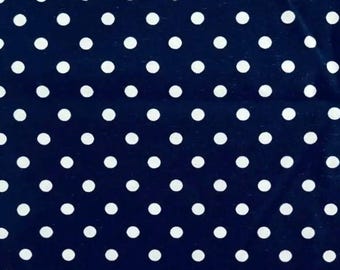 May include: A navy blue fabric with a repeating pattern of white polka dots. The dots are evenly spaced and create a classic, playful design. The fabric appears to be soft and could be used for clothing or home decor.