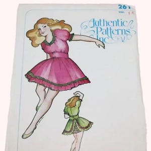 May include: A white sewing pattern envelope labeled Authentic Patterns Inc. 261 size 14, featuring a color illustration of a person with blonde hair wearing a pink dress with green trim and a smaller figure wearing a green dress with brown trim.
