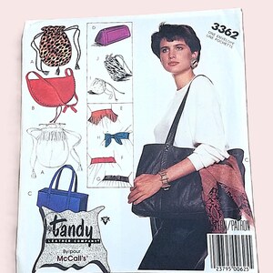 May include: A vintage sewing pattern with illustrations of different bag styles, such as a drawstring pouch and a tote bag. The pattern includes the text "tandy LEATHER COMPANY" and "McCall's". The model is wearing a black tote bag.