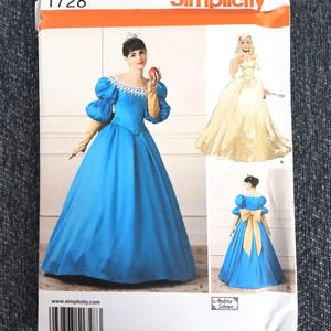 May include: Simplicity pattern 1728 shows illustrations of princess-style gowns. The main image features a woman in a blue gown with puff sleeves, a white lace collar, and gold gloves. Additional designs include a yellow gown and a blue gown with a gold bow.