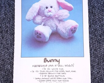 May include: A printed pattern for a plush bunny toy. The image shows a soft, pink bunny with a bow, and the pattern details materials like white fur, pink velour, and black buttons. The text reads "Bunny" and "ToyLady Press".