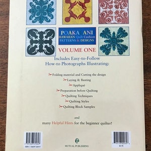 May include: The back cover of a book titled "POAKA ANI Hawaiian Quilt Cushion Patterns & Designs Volume One." It features colorful quilt block designs and includes instructions for quilting techniques. The book is published by Mutual Publishing.