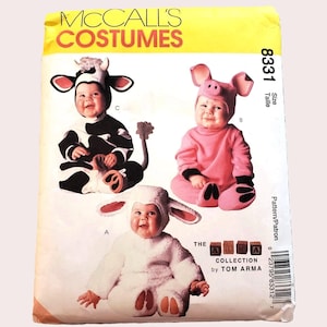 May include: McCall's Costumes pattern 8331 from The Tom Arma Collection. The envelope features illustrations of three infants wearing animal costumes: a black and white cow, a pink pig, and a white lamb. Each costume includes a hood with ears.
