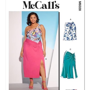 May include: McCall's sewing pattern featuring a woman wearing a one-shoulder top and a pink skirt with a side slit. The pattern includes illustrations of a floral skirt and a teal skirt. The text "McCall's" is at the top.