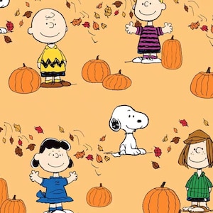 May include: A repeating pattern on a light orange background featuring Peanuts characters including Charlie Brown, Snoopy, Lucy, and Peppermint Patty. The design includes orange pumpkins and scattered autumn leaves in shades of red, brown, and yellow.