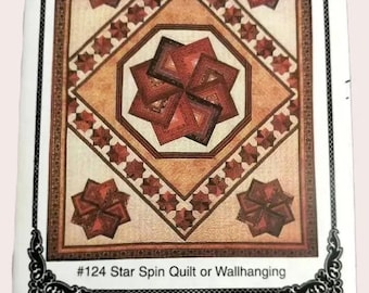 May include: A rectangular quilt pattern document titled #124 Star Spin Quilt or Wallhanging. The design features a central geometric star motif in shades of red and brown, surrounded by a diamond border and four corner star accents on a tan background.