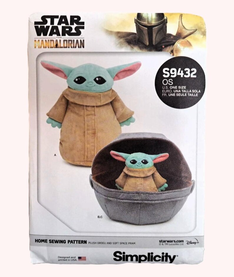 May include: A sewing pattern for a plush Grogu and soft space pram. The pattern features Grogu in a tan coat with large ears and a small plush Grogu in a gray pram. The Star Wars: The Mandalorian logo is at the top.
