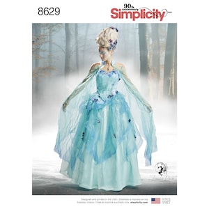 May include: A Simplicity 8629 sewing pattern featuring a light blue gown with a fitted bodice, a full skirt, and sheer, flowing cape-like sleeves. The dress is adorned with small floral accents. The pattern includes the 90th anniversary logo.
