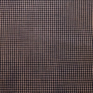 May include: Close-up of a fabric with a classic gingham pattern. The fabric features a repeating grid of small, evenly spaced squares in a dark navy blue and a light tan color. The texture appears soft and slightly textured.