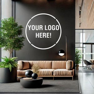 Könnte beinhalten: Eine moderne Bürolobby mit einer Holzdecke, schwarzen Wänden und einem braunen Ledersofa. Die Wand hat einen weißen Kreis mit dem Text "YOUR LOGO HERE!" in der Mitte. Es gibt Pflanzen in Töpfen und schwarze Pendelleuchten, die von der Decke hängen.