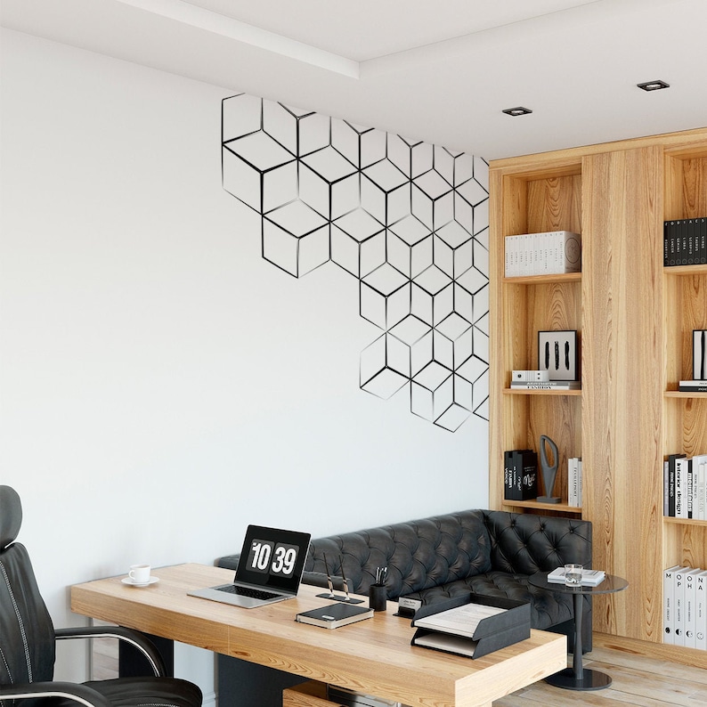 May include: A modern home office with a black leather sofa, a wooden desk with a laptop, a cup of coffee, and a digital clock displaying 10:39. The wall features a geometric pattern of black cubes.