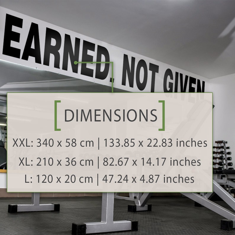 May include: A white sign with black text that reads "EARNED, NOT GIVEN" and a list of dimensions in centimeters and inches. The sign is hanging from the ceiling in a gym.