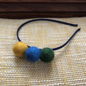 Felted wool pom pom headband in gold, green, and blue