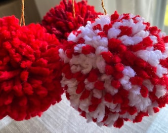 Set of three red and white pom pom ornaments